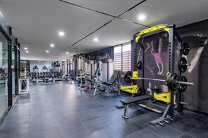 A gym with various weightlifting equipment, including barbells and weight plates. - Fei Li International Hotel (Guangzhou)