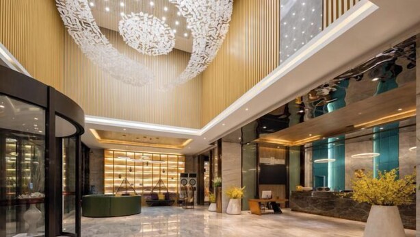 Un'ampia hall con soffitto alto, una reception e un'area salotto.