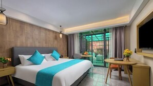 Una camera d'albergo con un letto, una scrivania, una sedia, un tavolino e una TV.