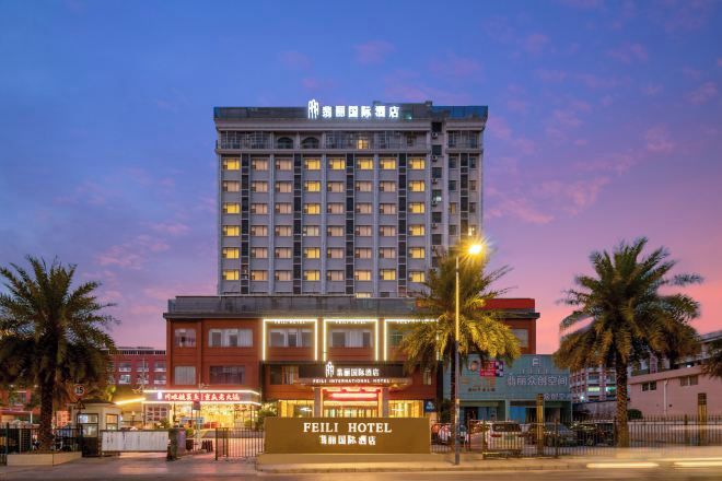 A multi-story hotel with a prominent sign for the Feili Hotel.