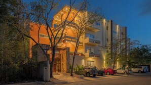A multi-story building with a modern architectural design, featuring balconies and a central entrance. - Incredible private property: 2 apartments with wifi, pool and nearby cenote (Tulum)