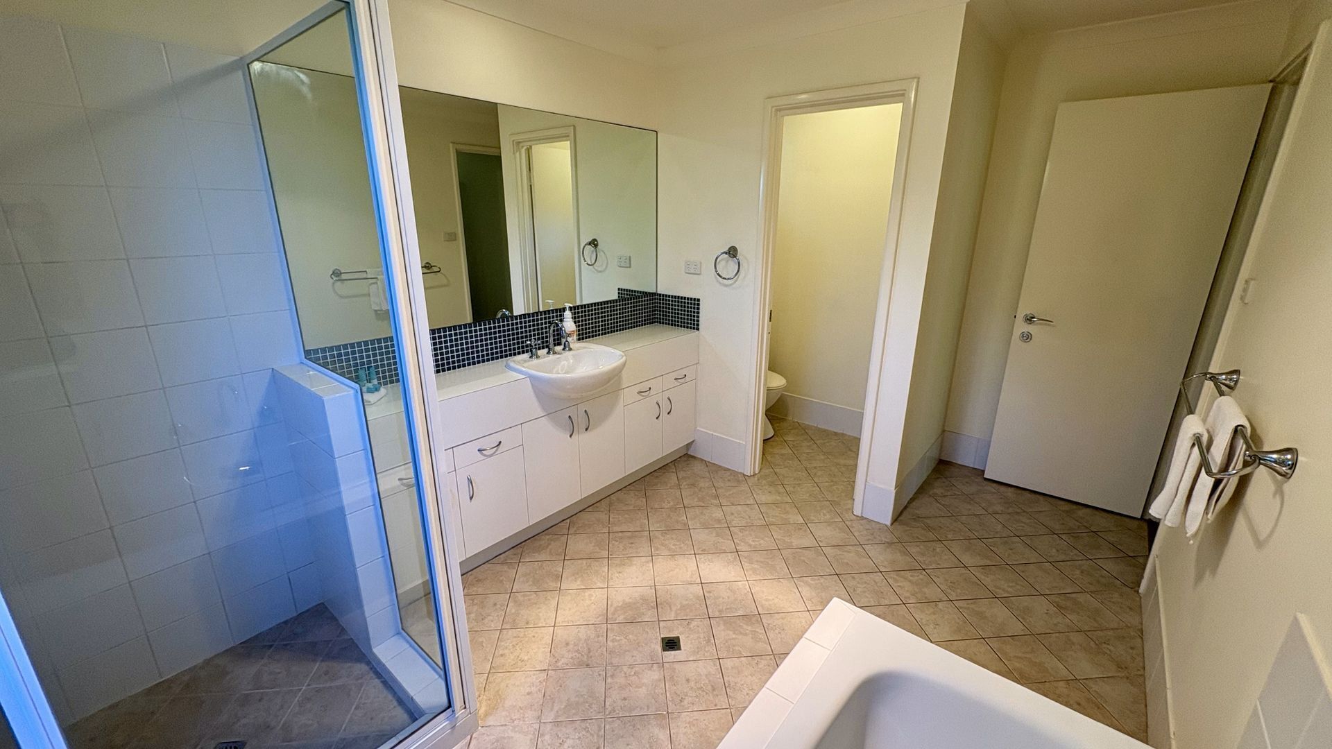 Une salle de bain avec une douche, un lavabo et des toilettes.
