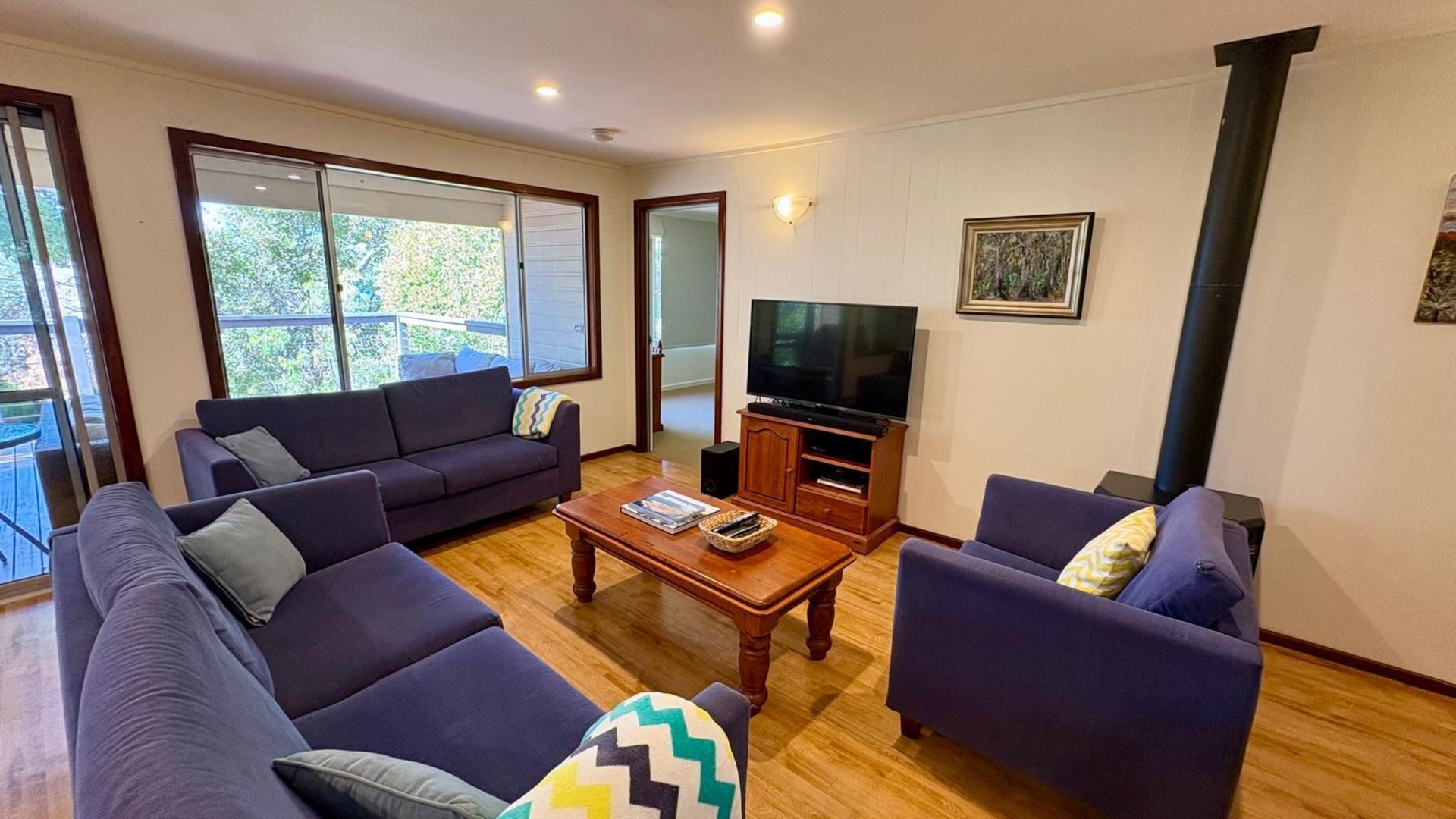 A living room with a sofa set, a coffee table, a TV, and a fireplace.