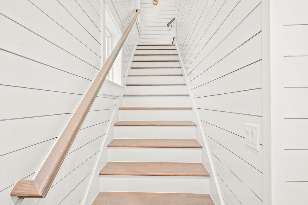 A staircase with white walls and wooden steps.