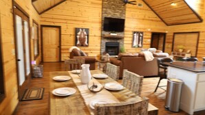 A wooden cabin interior with a dining area, living room, and kitchen. - Open concept, 4 bd/4bath cabin in the woods, sleeps 12. Great location! (Broken Bow)