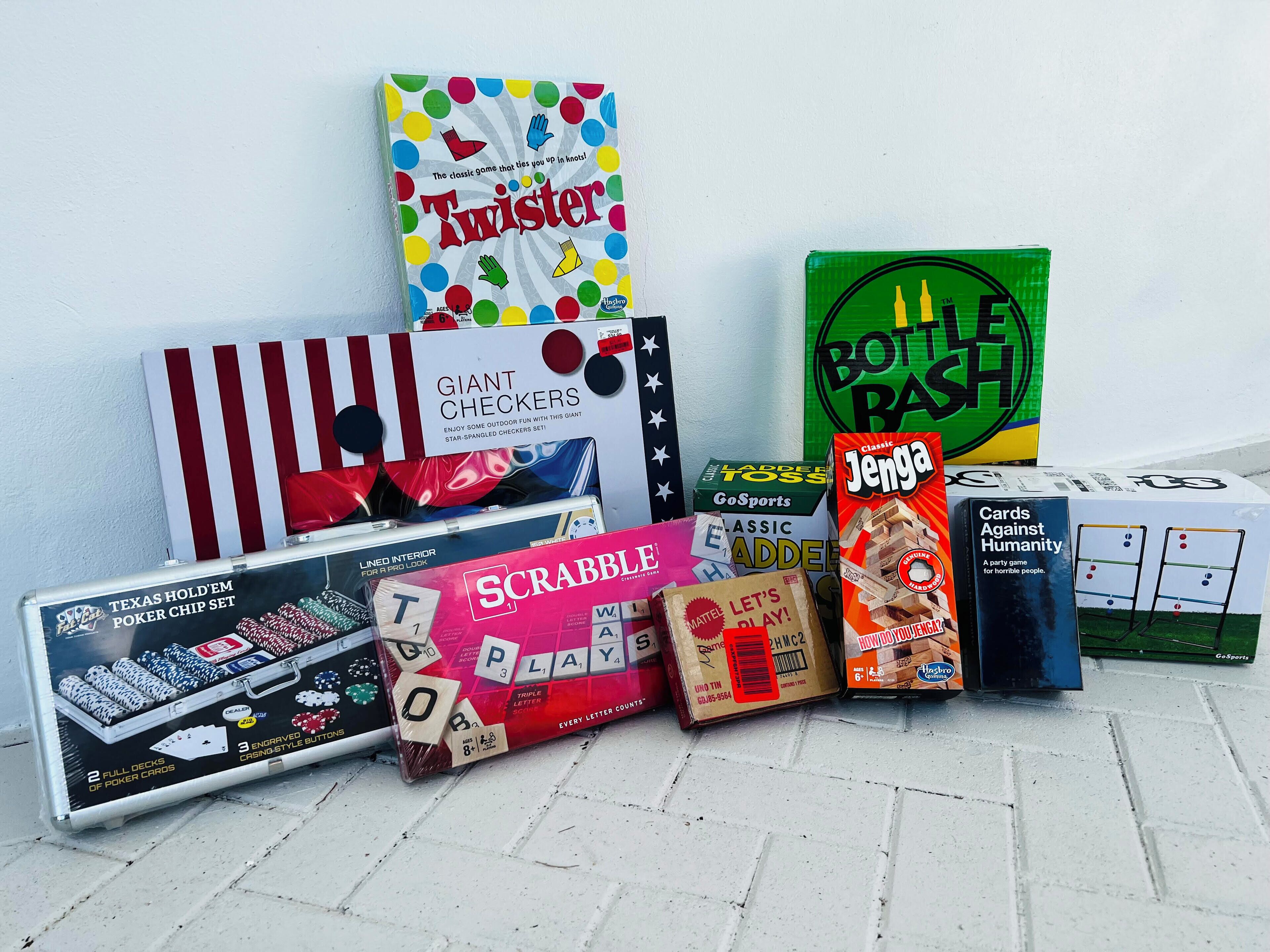 A variety of board games including Twister, Giant Checkers, Scrabble, Texas Hold'em Poker Chip Set, Jenga, and Cards Against Humanity.