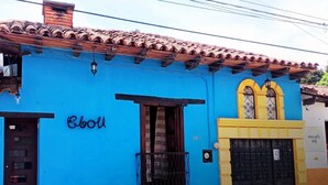 Un edificio con fachada azul, base amarilla y techo de tejas.