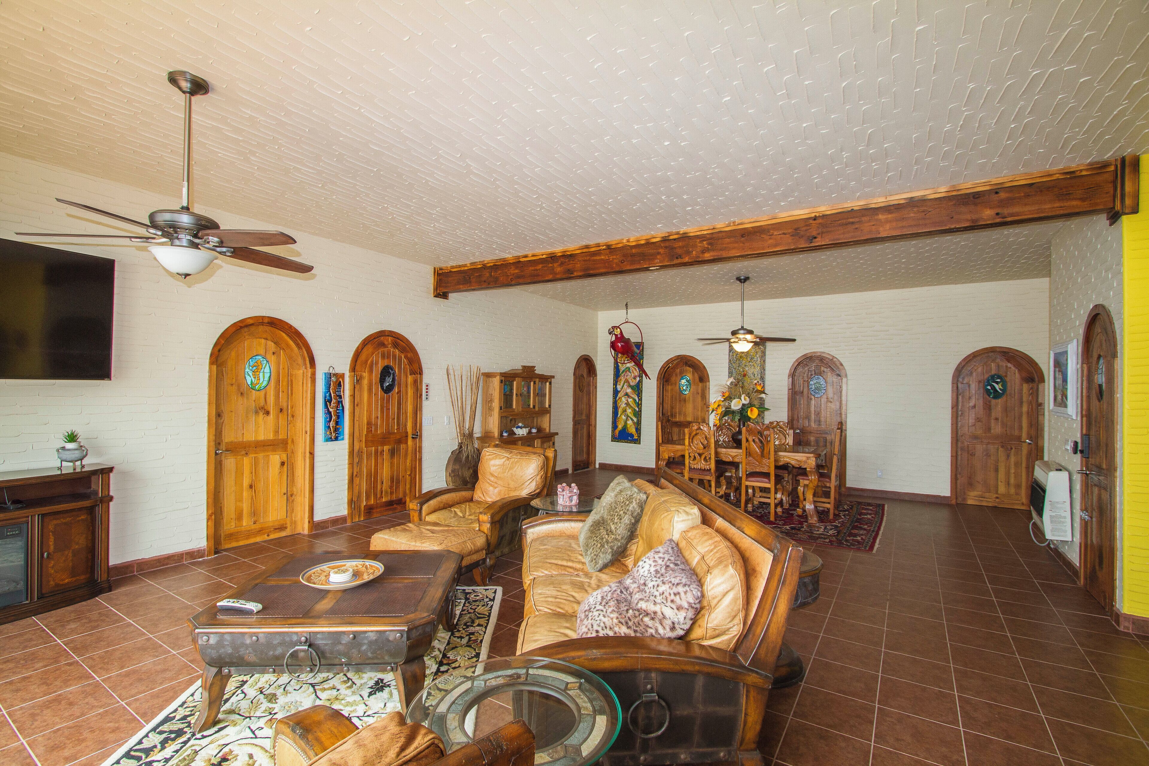 A spacious living room with a high ceiling, wooden doors, and a large seating area.