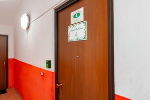 A hotel room with a wooden door, a wall-mounted light fixture, and a sign indicating room number 96. - Grotta della Natura (Turin)