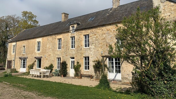 A stone building with multiple windows, a small garden with a table and chairs, and a chimney. - Exceptional group gîte for families, friends, professionals 24 pers. (Lingèvres)