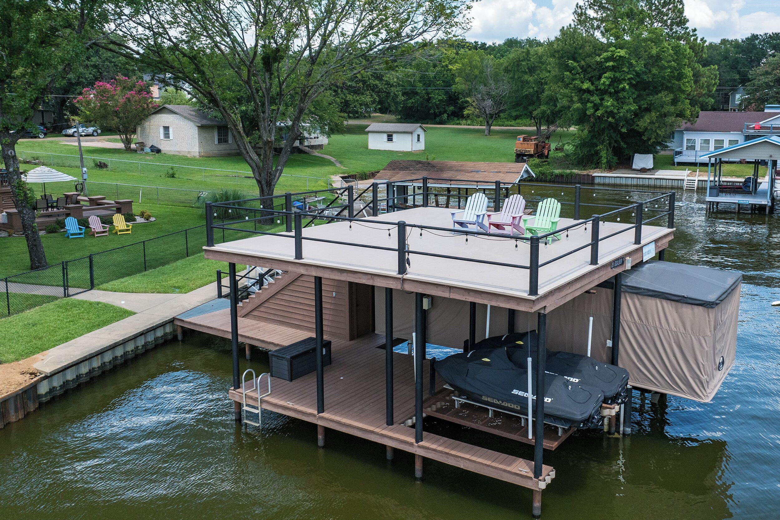A floating deck with seating and a covered area, surrounded by water.
