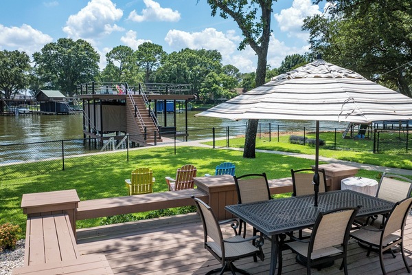 Outdoor table with seating for 6 with an umbrella on raised deck