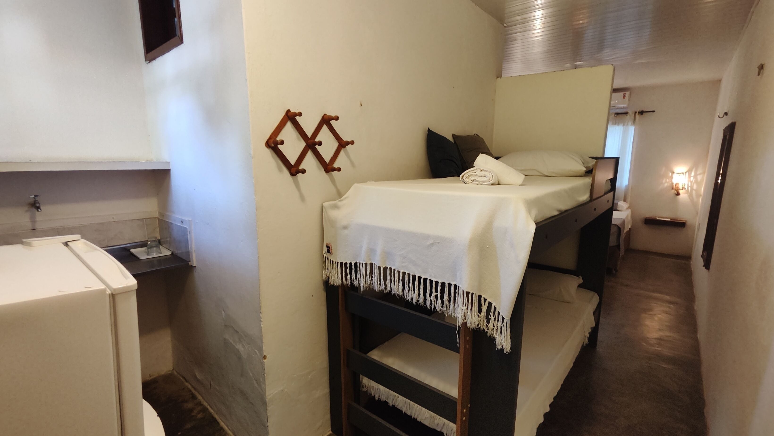 Une petite pièce avec des lits superposés, un petit bureau et un radiateur fixé au mur.