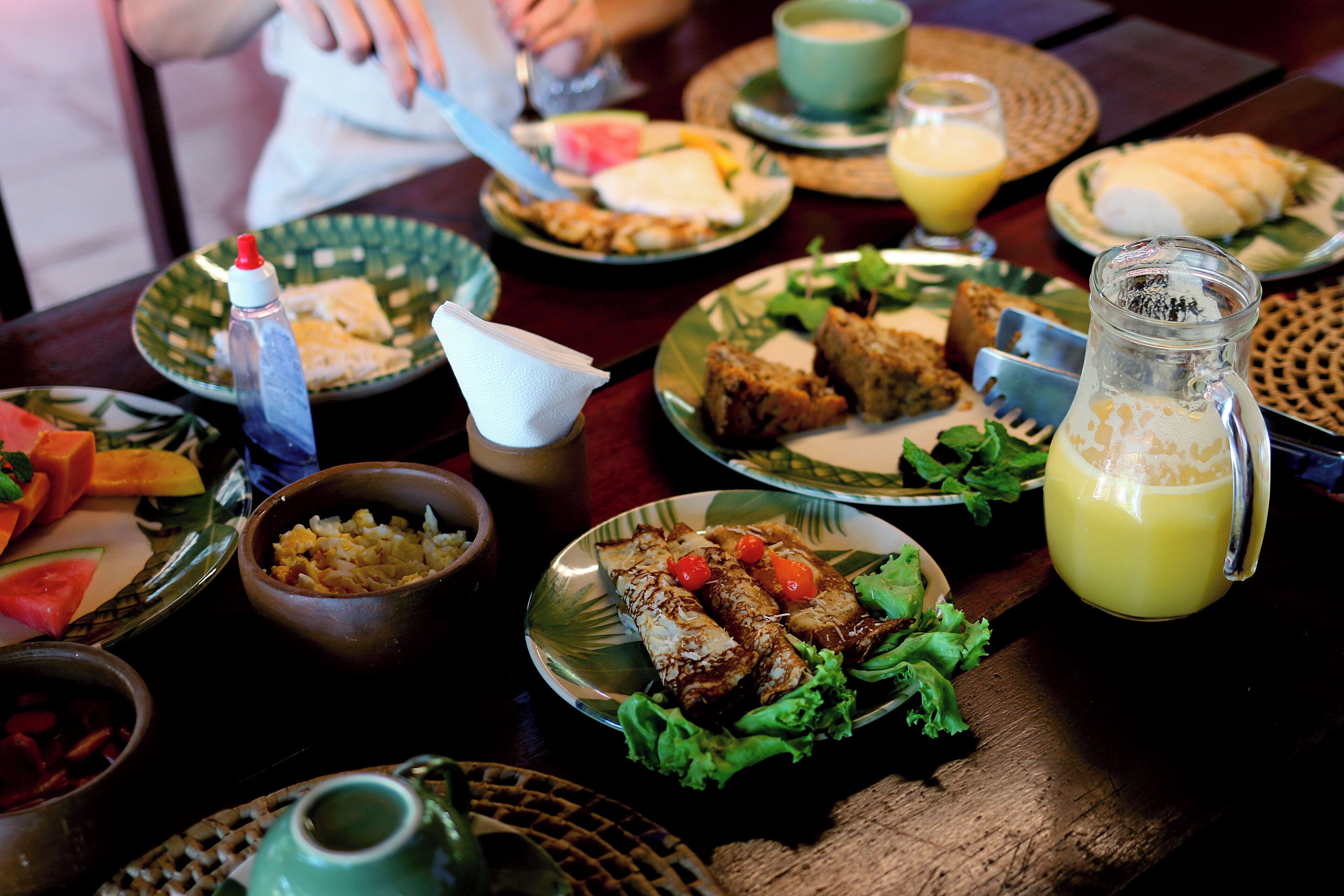 A table set with various dishes, including sandwiches, salads, and a pitcher of juice.
