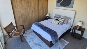 A bedroom with a bed, a chair, a nightstand, and a large window. - Incredible new apartment in Centro Zapopan 603A (Zapopan)