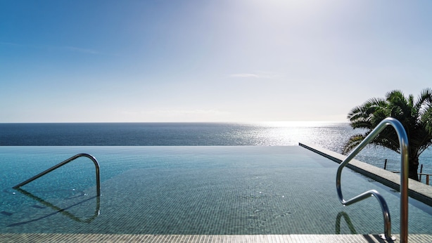 An infinity pool with clear blue water and a view of the ocean. - With pool and sea view - Acqua Residence III (Funchal)