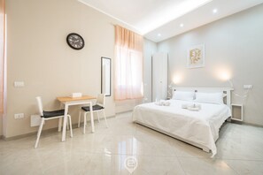 Una habitación de hotel moderna con cama, escritorio, sillas, un reloj y una ventana con cortinas.