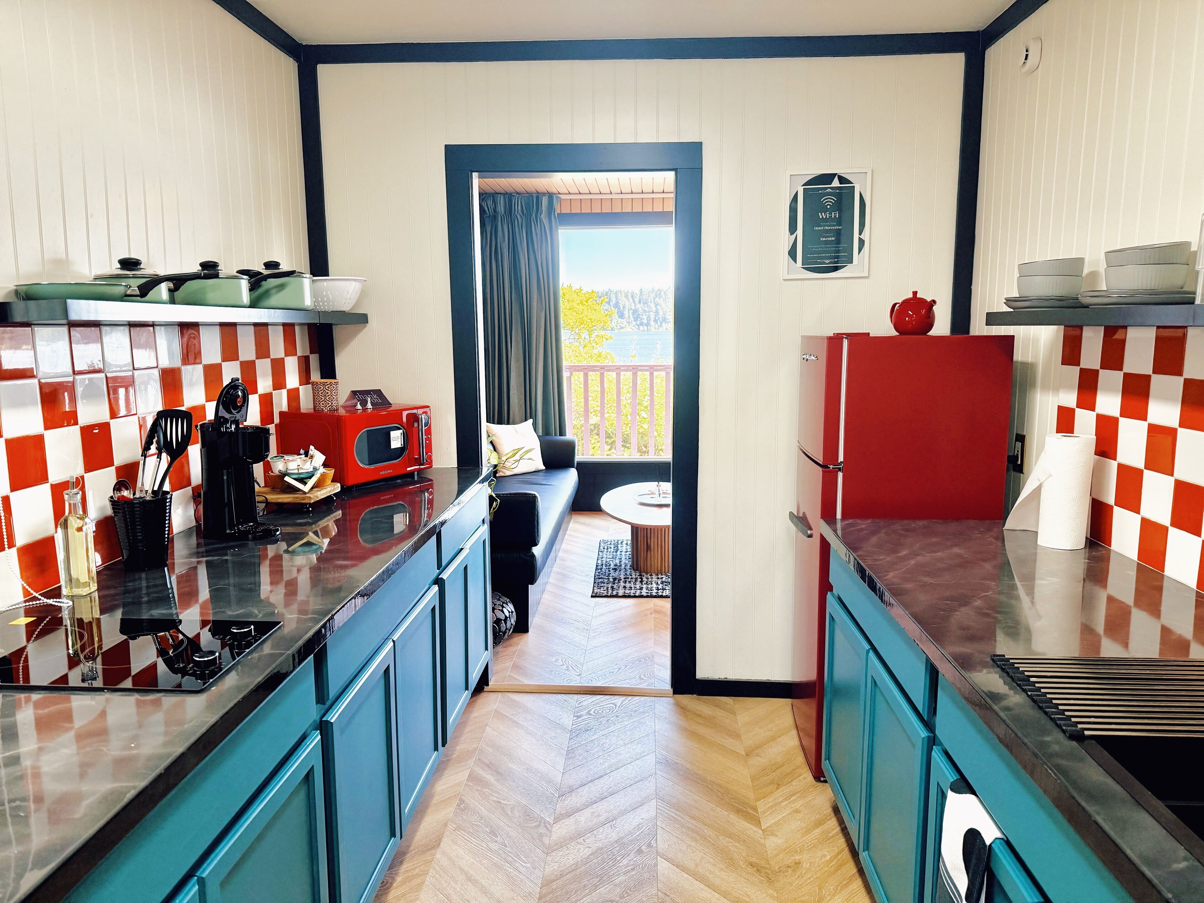 A kitchen with checkered tile backsplash, a refrigerator, a microwave, and a coffee maker.