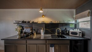 A modern kitchen with a large island, stainless steel appliances, and a wooden ceiling. - The Florentine Waterfront Hotel (Dunes City)