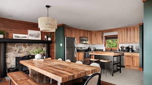 Une cuisine moderne avec des meubles en bois, un îlot central et une cheminée en pierre.