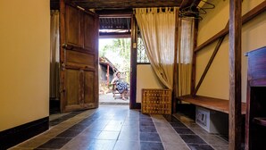 A hallway with a wooden door, a bench, and a small table with a radio. - PURE Gym - Spa - Yoga - Lodging (Granada)