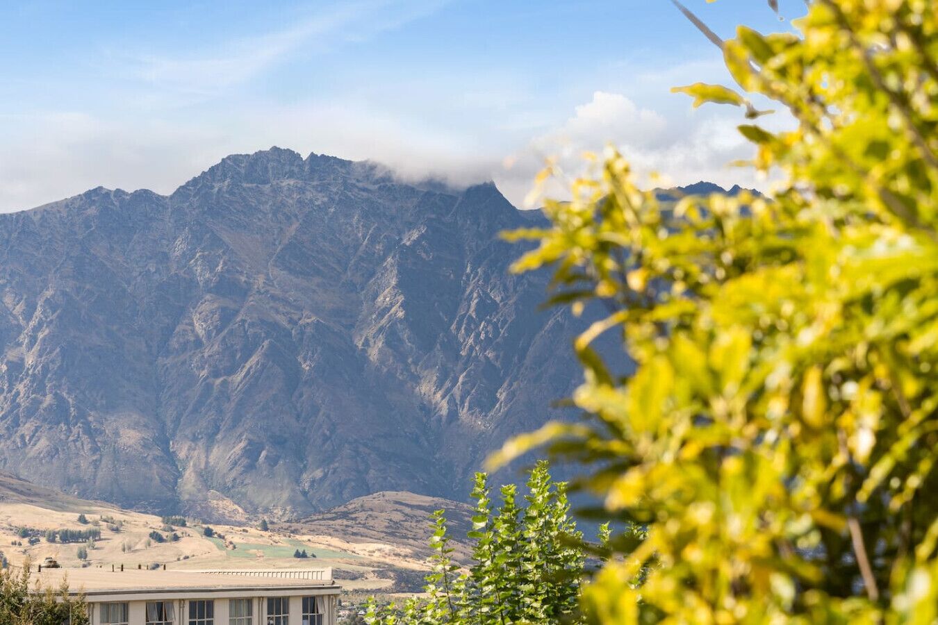 A mountainous landscape with a building in the foreground.