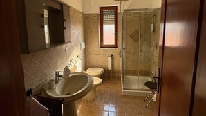 A bathroom with a sink, toilet, and shower.