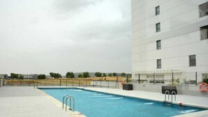 A swimming pool with a metal ladder, surrounded by a paved deck. - Timeless Elegance in Rivas (Rivas-Vaciamadrid)