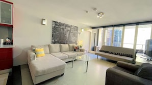 A modern living room with a sectional sofa, a glass coffee table, and a flat-screen TV. - Sydney CBD 2Bedroom Apartment (Sydney)