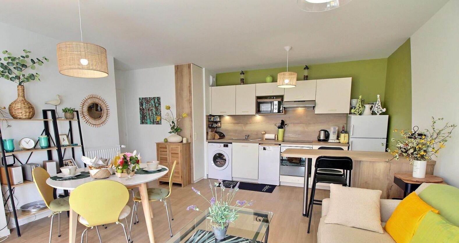 Un espace de vie compact comprenant un coin repas, une cuisine et un coin salon.