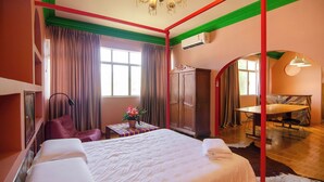 Una habitación de hotel con una cama grande, un escritorio, un armario y una zona de comedor.