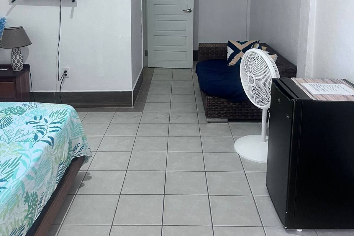Una habitación de hotel con una cama, un escritorio, una silla, un televisor y una puerta.