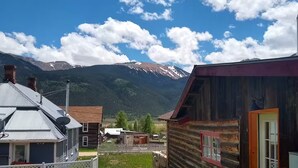 A mountain village with wooden buildings, a clear sky, and snow-capped peaks in the background. - Crib house studio cabin - mountain views, .25mls to lake, quiet comfort! (Twin Lakes)