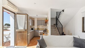 A compact living space with a kitchenette, a dining area, and a staircase leading to an upper level. - Holiday Home 'Casa Centro' with Sea View, Wi-Fi and Air Conditioning (Mijas)