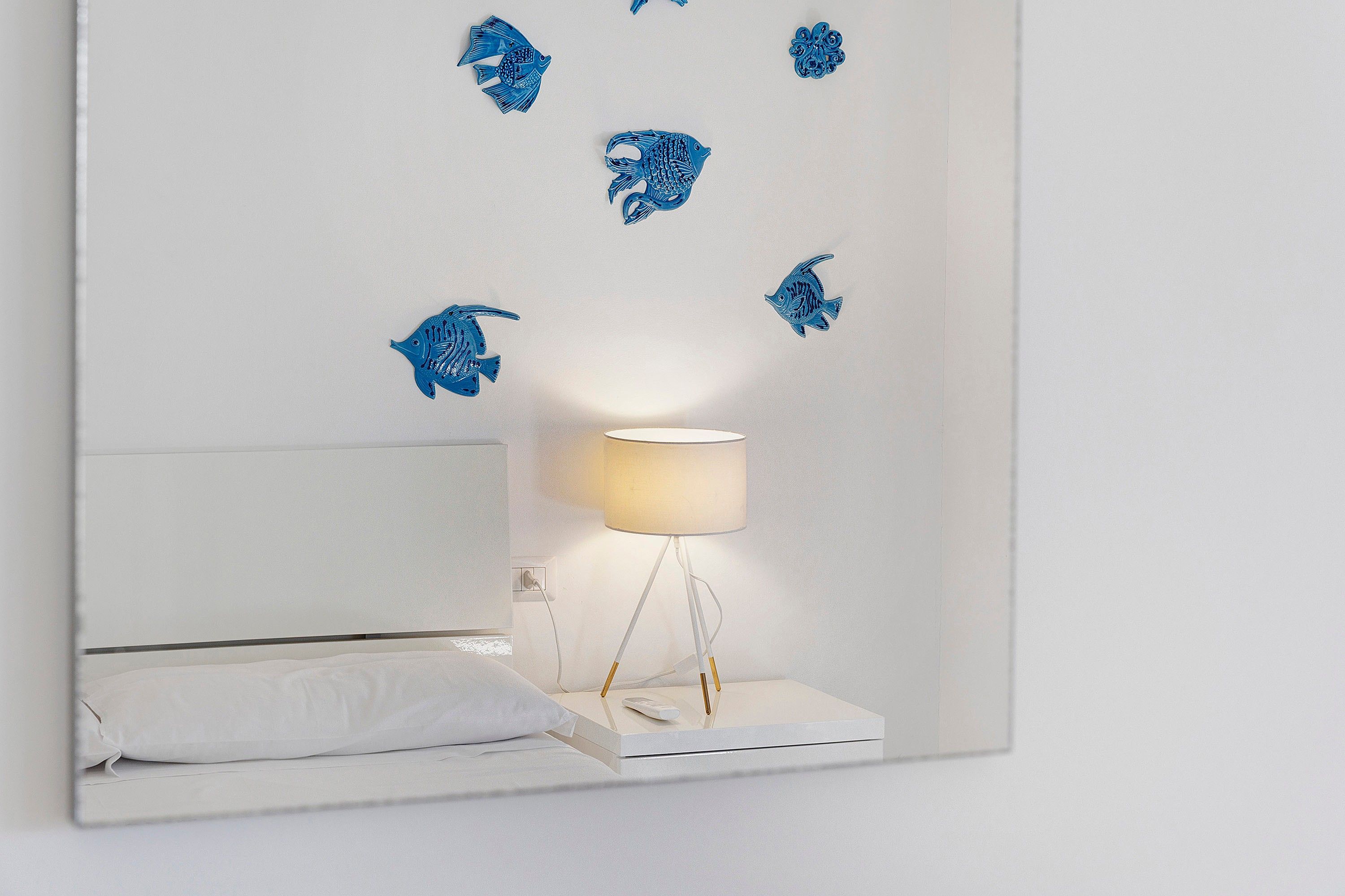 A bedroom with a bed, a bedside table, and a lamp.
