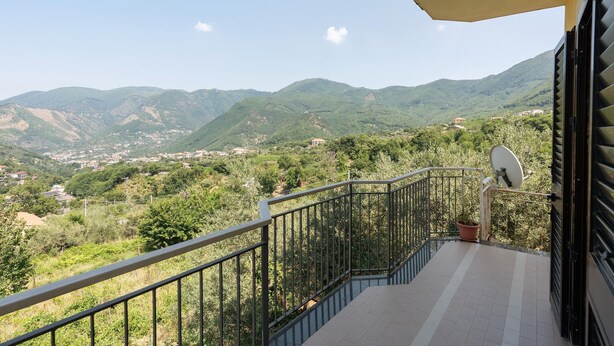 A balcony with a metal railing, a potted plant, and a satellite dish. - Room 'Tripla Con Vista Montagna' with Mountain View, Shared Garden and Wi-Fi (Pimonte)