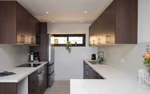A modern kitchen with dark wooden cabinets, stainless steel appliances, and a white countertop. - Ref: 281 Stunning villa with private pool (Fuengirola)