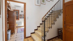 A staircase with a wooden handrail, a small wooden stool, and a door on the right. - Holiday Home 'Lina' with Private Terrace, Wi-Fi and Air Conditioning (Villemolaque)