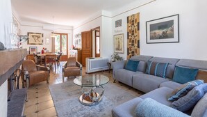 A living room with a sofa, armchairs, a glass coffee table, and a TV. - Holiday Home 'Lina' with Private Terrace, Wi-Fi and Air Conditioning (Villemolaque)
