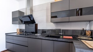 A modern kitchen with a built-in stove, a sink, and a large window. - Holiday Home 'Lina' with Private Terrace, Wi-Fi and Air Conditioning (Villemolaque)