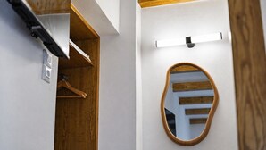 A room with a wooden wardrobe, a mirror, and a light fixture. - Traditional Κefalos Apt with Wooden Ceilings (Kos)