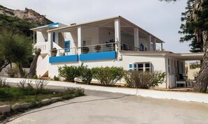 A two-story building with a balcony, a covered area, and a view of a hill. - Holiday Home 'Two Bedroom' with Sea View, Wi-Fi and Air Conditioning (Kos)