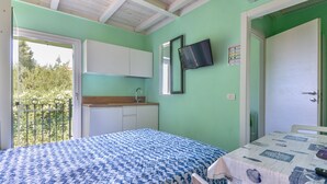 A room with a bed, a table, a sink, and a mirror.