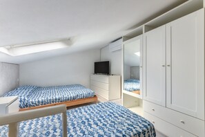 A bedroom with a bunk bed, a TV, a wardrobe, and a desk. - Apartment 'Loft Scirocco' with Wi-Fi and Air Conditioning (Rio Marina)