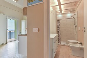 A modern bathroom with a shower, toilet, and bidet.
