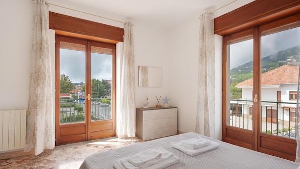 Un dormitorio con cama, cómoda y vista al exterior.