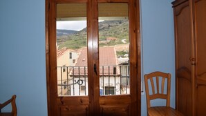A wooden door with a view of a residential area, a chair, and a cabinet.
