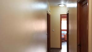 A hallway with a marble floor, beige walls, and wooden doors. - Room 'Twin Con Balcón' with Balcony and Wi-Fi (Villarluengo)