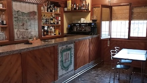 A bar area with wooden paneling, a coffee machine, and a tiled backsplash. - Room 'Twin Con Balcón' with Balcony and Wi-Fi (Villarluengo)