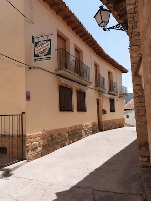 Un immeuble avec une enseigne indiquant « San Miguel Habitations », des balcons et une vue sur la rue.